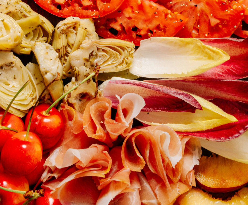 Close up of tomatoes, artichoke, and prosciutto