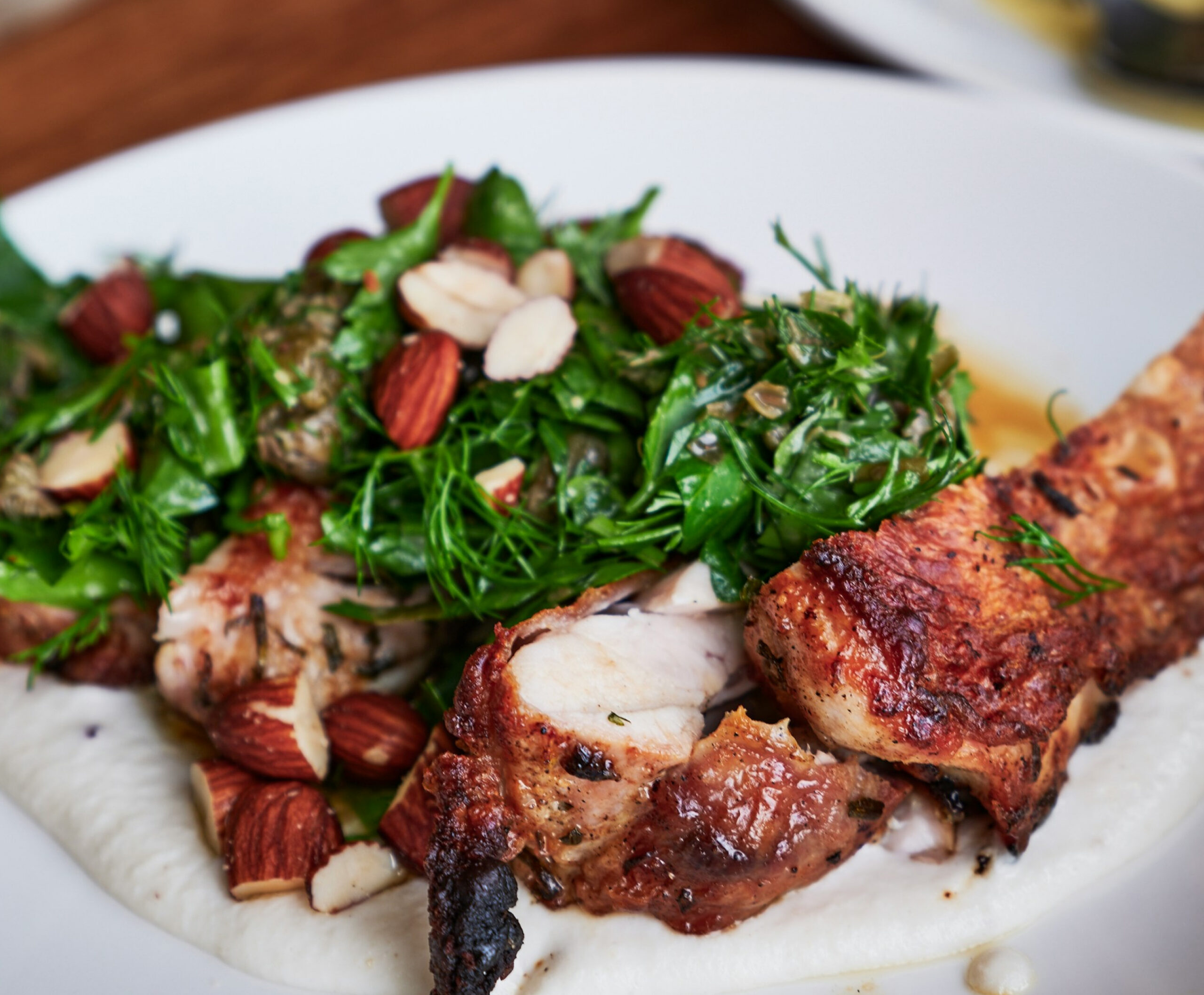 Close up of grilled chicken with greens and nuts