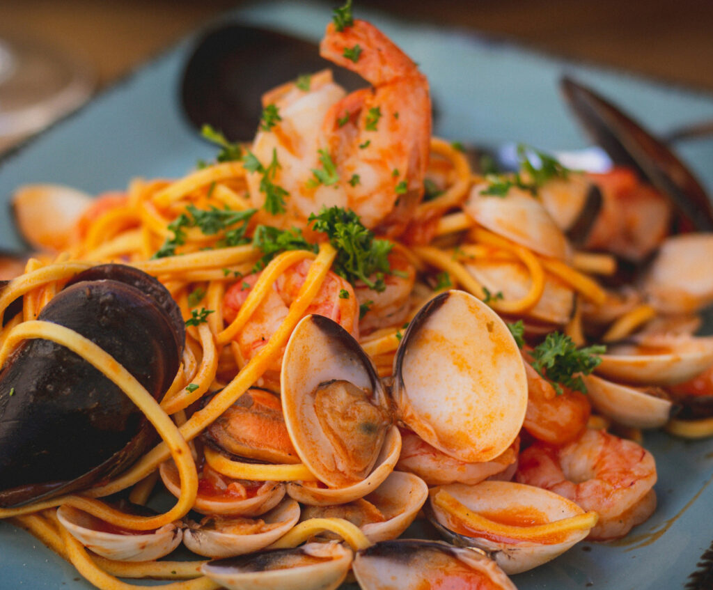 Close up of shrimp and mussels in red sauce with pasta