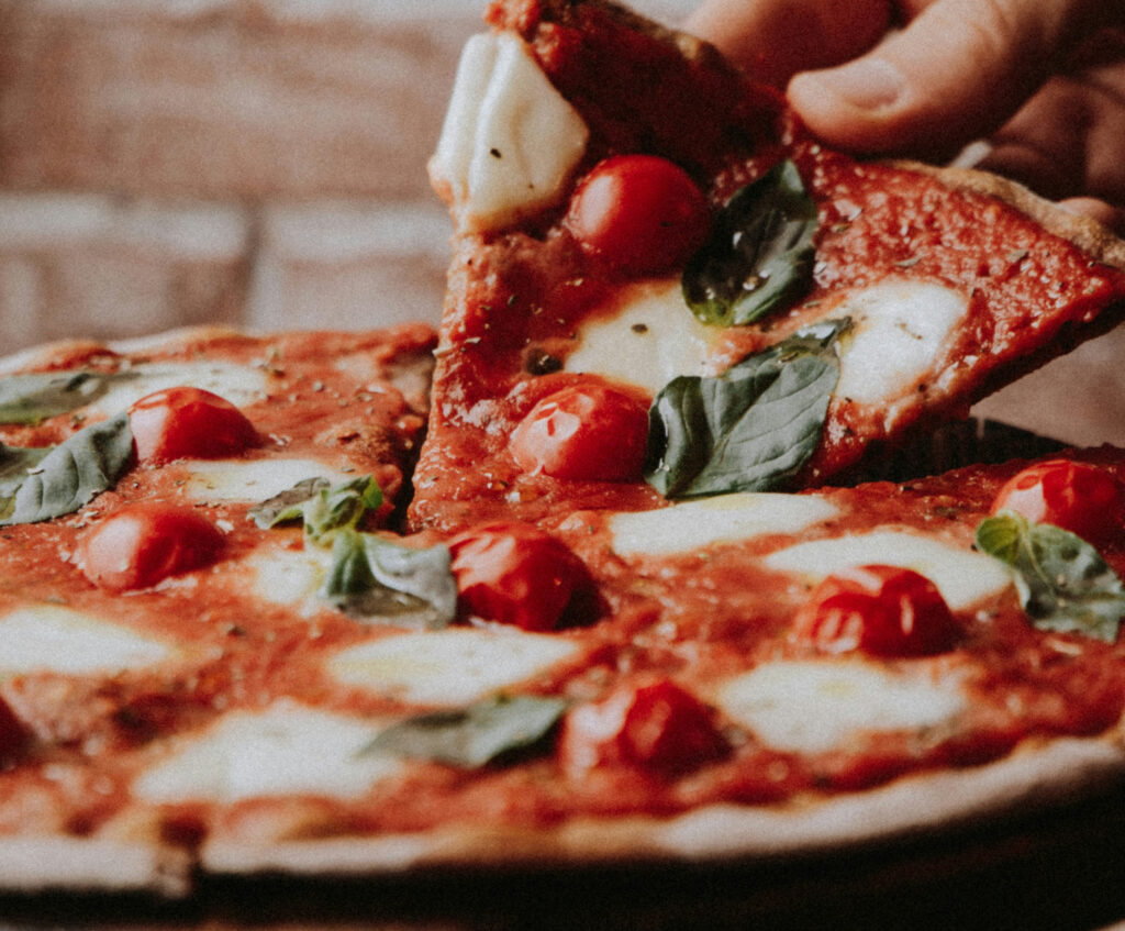 Close up of pizza slice being pulled away from pizza pie